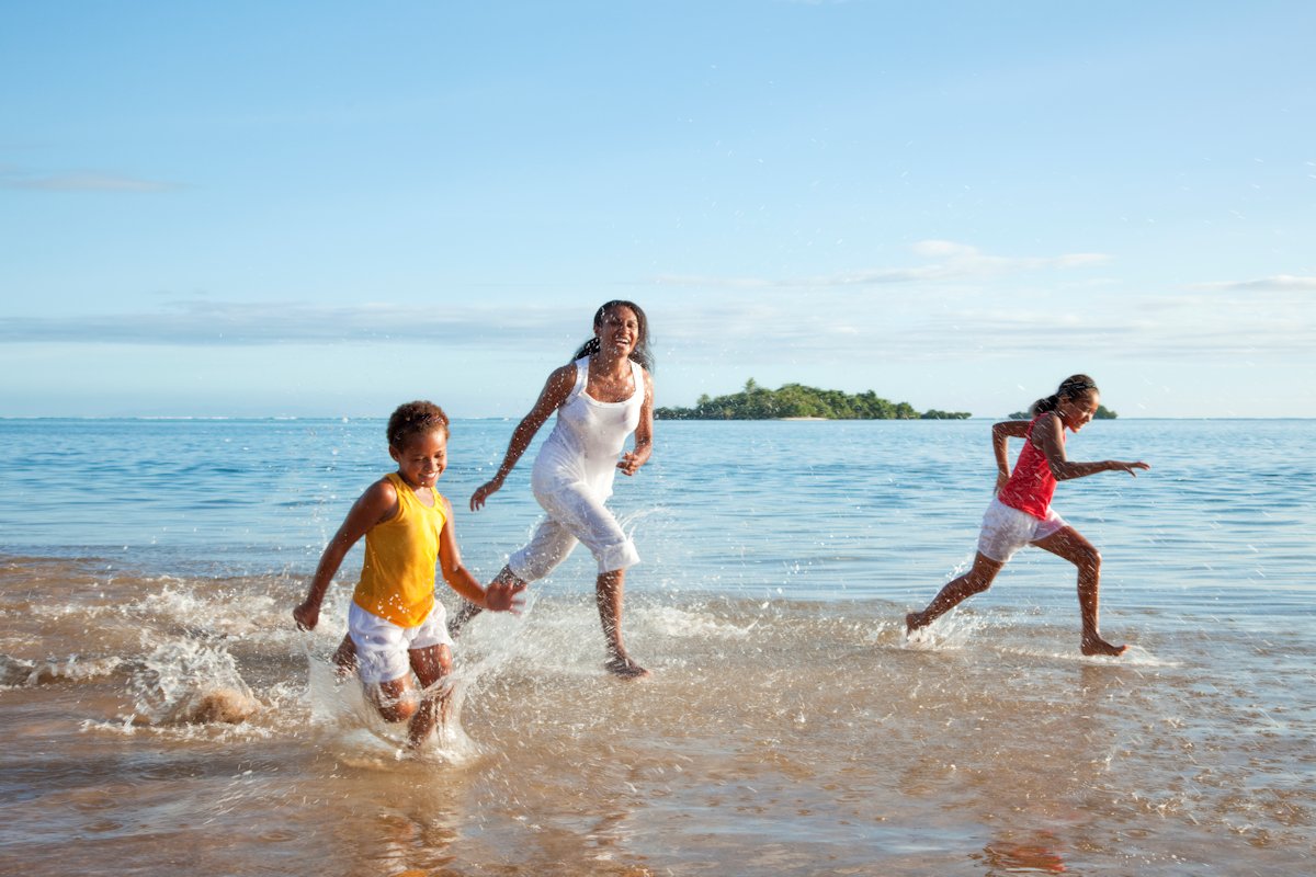 Single Parent playing with children on beach