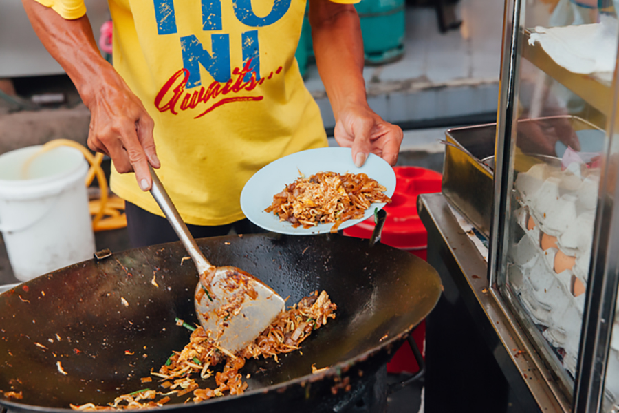 Man cooks Malaysian food in street market